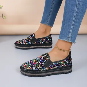 Gros plan de mocassins à paillettes multicolores avec bout rond et semelle plate épaisse.