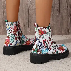 Detail shot of white combat boots with vibrant floral embroidery and thick soles