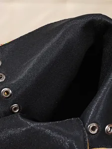 Detailansicht des Futters und der silbernen Ösen an schwarzen Satin-Stiefeln.
