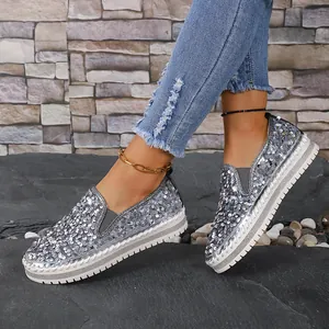 Vue détaillée de mocassins plats pour femmes avec paillettes argentées et semelle blanche.