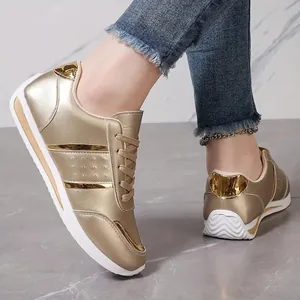 Detailed side view of stylish gold metallic faux leather women's casual sneakers
