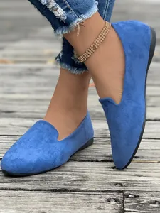 Primo piano di ballerine in camoscio blu vivace indossate su un pontile