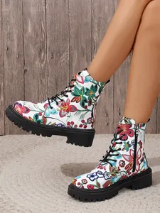 Detailed view of white combat boots with vibrant floral embroidery and black lug soles.