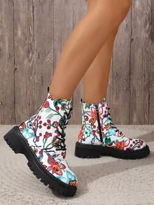 Detail view of floral print lace-up combat boots with thick lug sole and side zipper