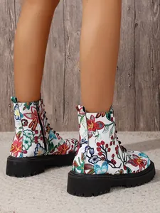 Detailed view of women's white combat boots featuring vibrant floral embroidery and thick soles.