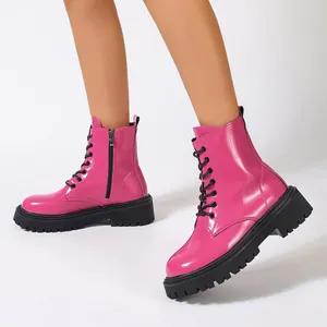 Vue détaillée de bottines de combat à plateforme en cuir verni rose vif pour femmes élégantes