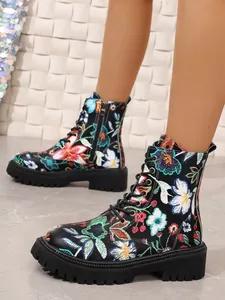 Detailed view of floral print lace-up Martin boots with chunky soles and side zippers.