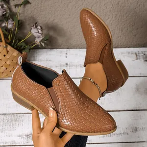 Close-up of brown woven texture pointed-toe loafers with elastic side panels