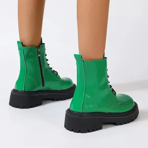 Bottines à plateforme en cuir verni vert vif avec une semelle épaisse et des lacets.