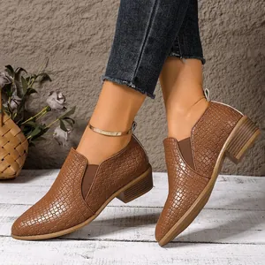 Close-up detail of stylish brown woven texture pointed toe low heel loafers worn by model