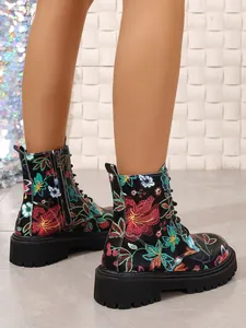 Detail view of women's Martin boots with vibrant floral embroidery and thick soles.