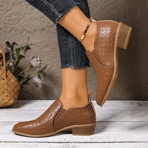 Detail of brown woven crocodile texture low-heel ankle shoes with pointed toe worn by model