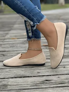 Vista laterale dettagliata di scarpe basse in camoscio beige da donna con punta tonda