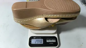 Detailed view of lightweight women's gold wedge sandal weighing 294.8g on a digital scale
