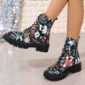 Close-up of black Martin boots with colorful floral prints and thick lug soles.