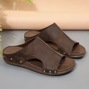 Gros plan de sandales à plateforme marron avec cuir usé et détails de clous en métal