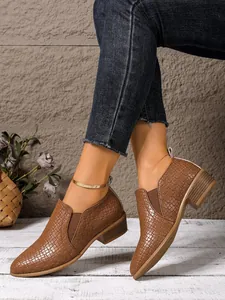 Side view of brown woven textured pointed toe ankle boots with low block heels.