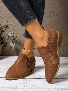 Detailed view of women's brown woven texture pointed toe ankle boots with thick heel