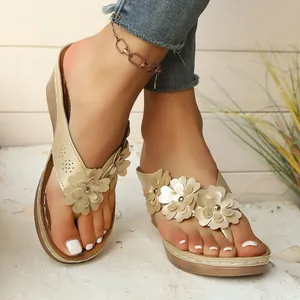 Detailed view of champagne gold wedge sandals featuring decorative 3D floral petal accents