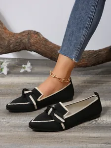 Stylish black knit pointed-toe flat shoes featuring elegant bow detail and contrast trim