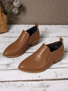 Close-up of brown pointed-toe ankle boots with woven texture and block heel detail