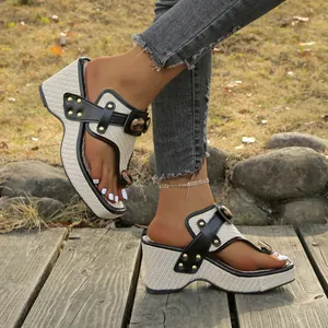 Close-up of stylish woven platform wedge thong sandals with leopard buckle and gold studs