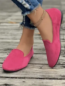 Primo piano di mocassini piatti in pelle scamosciata rosa da donna con punta arrotondata.