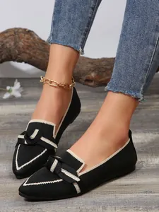 Elegant black pointed-toe knit flats with bow detail and chic beige trim accents