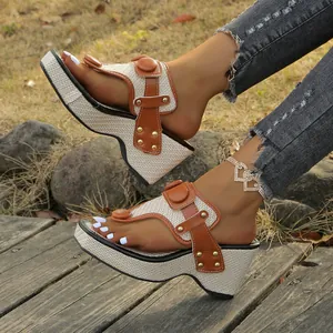 Close-up of brown leather wedge thong sandals with woven platform and metal buckle