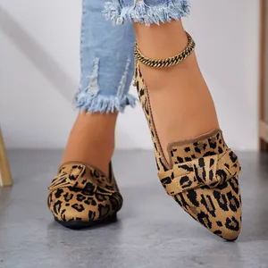 Close-up detail of stylish leopard print knit pointed-toe flats on model's feet