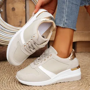 Close-up of beige thick-soled sneakers with gold metallic details and suede textures