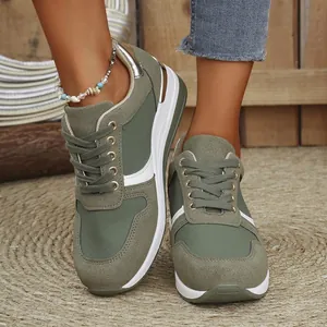 Close-up detail of stylish green platform sneakers for women on a rustic woven mat