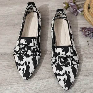 Detailed view of stylish black and white knit pointed-toe flat loafers for women.