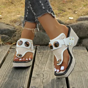 Close-up view of women's woven wedge thong sandals with leopard print button details