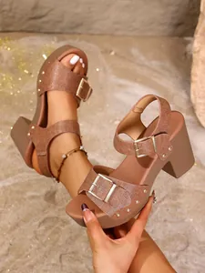 Close-up of brown chunky heel sandals featuring rivet details and metallic buckle.