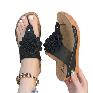 Elegante schwarze Keilsandaletten mit Blumen-Detail und Plateausohle für den Sommer.