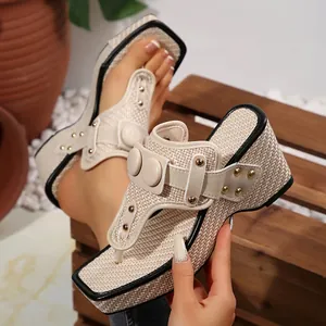 Detail view of a beige woven wedge thong sandal featuring metallic stud accents.