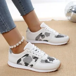 Close-up detail of women's camouflage print lace-up casual sneakers worn on model