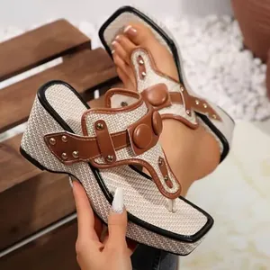 Close-up of brown leather straps with metal studs on woven wedge sandals