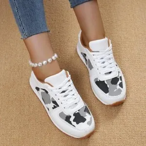 Close-up view of stylish white sneakers featuring grey leopard print panels and white laces