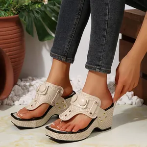 Detailed view of stylish wedge thong sandals with woven texture and gold stud accents