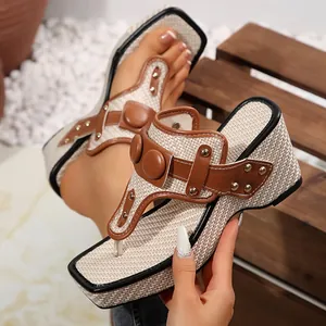 Detail of wedge thong sandals with woven texture and decorative metal studs.