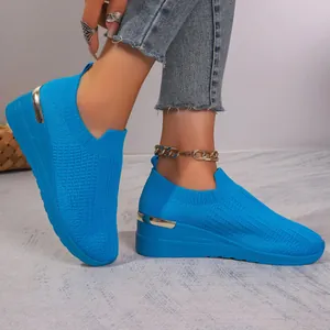 Close-up of blue fly-knit mesh wedge sneakers with stylish metallic heel detail