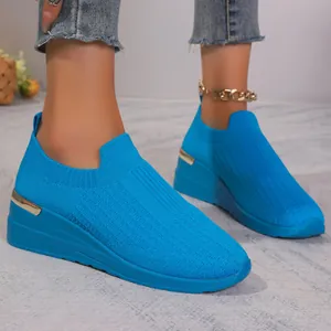 Detailed view of blue knit mesh slip-on sneakers with stylish wedge heels for women.