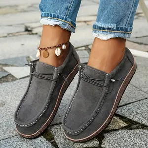 Close-up view of women's ethnic style grey loafers with thick cork soles and stitching