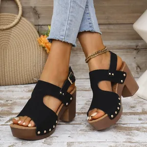 Detail van zwarte dames sandalen met klinknagels, chunky hakken en een dikke platform zool.
