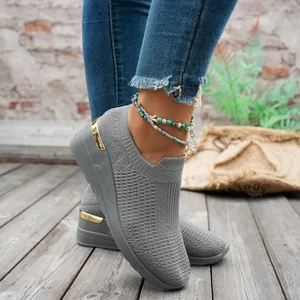 Close-up detail of grey mesh platform sneakers with knit upper and gold heel trim