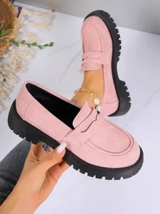 Close-up detail of stylish pink platform loafers with thick black lug sole for women
