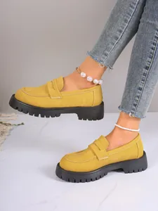 Yellow platform loafers in British style with chunky thick soles worn with jeans