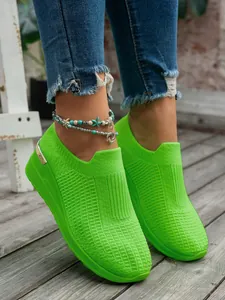 Close-up of vibrant green flyknit platform sneakers for women with mesh texture